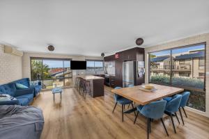 梅林布拉Capri Apartments的厨房以及带桌椅的起居室。