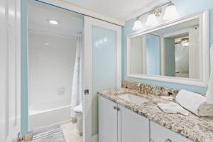 开普迪瓦South Seas Beach Villa 2412 condo的一间带水槽、镜子和淋浴的浴室