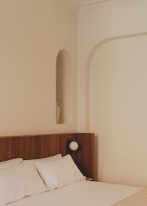 巴塞罗那Casa Llimona Hotel Boutique的一间卧室配有一张带木制床头板的床