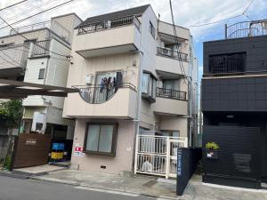 东京Cozy inn Oyama的大街上高大的白色建筑,设有阳台