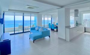曼塔The Best Luxury Penthouse - Beach View的一间带蓝色沙发的客厅和一间厨房