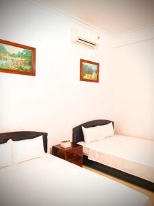 Kỳ VĩTruong Yen Hotel Ninh Binh的一间设有两张床的房间,中间设有床头柜
