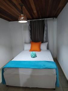 门德斯Casa de Campo: Sítio Santa Helena-Mendes RJ的一张床上有橙色和蓝色枕头的床