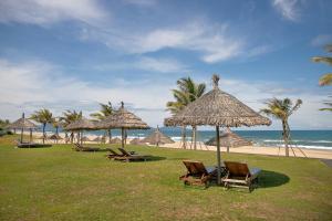 岘港Ocean Villa Pool Retreat In Da Nang的海滩上的一组椅子和遮阳伞