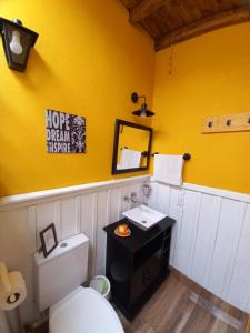 伊瓜苏港Mary's House的浴室设有白色卫生间和黄色墙壁。