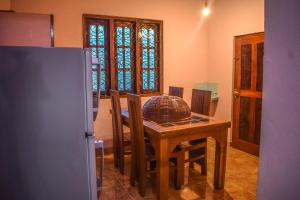 KamburugamuwaPENGIRIWATTA REST INN的厨房配有桌椅和冰箱。