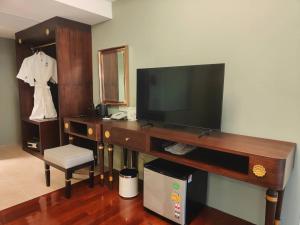 曼谷Siri Grand Bangkok Hotel的客厅配有电视、书桌和椅子