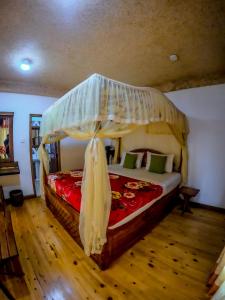 埃拉Mountain Range Cottage的一间卧室配有一张带天蓬的大床