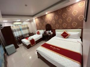 海防Khách Sạn Nam Sơn的酒店客房配有两张床和一张书桌