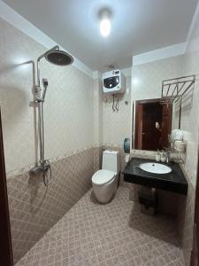 海防Khách Sạn Nam Sơn的浴室配有卫生间、盥洗盆和淋浴。
