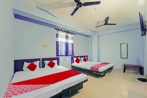 巴特那Super OYO Flagship Glad Guest House的一间卧室配有两张带红白色枕头的床