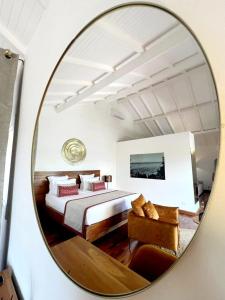 贝岛Andriana Resort & Spa的镜子反射着一间卧室,卧室配有一张床和一张沙发