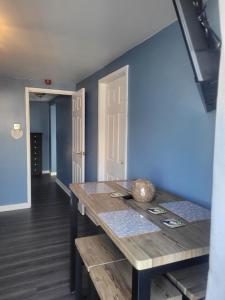 安布尔Amble Harbour retreats的一间设有木桌和蓝色墙壁的用餐室
