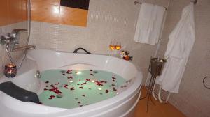代温Хотел Стиляна/Hotel Stilyana的地板上设有带鲜花大浴缸的浴室