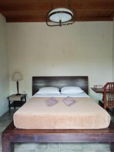 姆杜克古鲁拉特纳民宿的一间卧室配有一张大床和木制床头板
