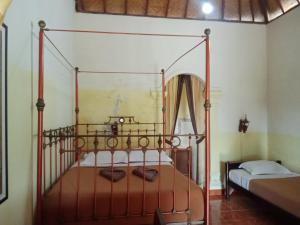 姆杜克古鲁拉特纳民宿的一间在客房内配有金属华盖床的卧室