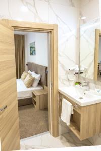 普罗夫迪夫Evelin Deluxe House的一间带水槽和镜子的浴室以及一张床