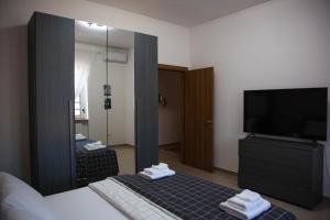 孔韦尔萨诺Doraci Home的一间带镜子、一张床和电视的卧室