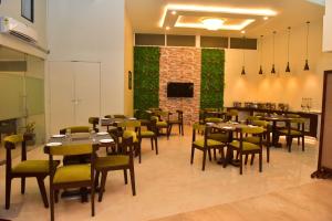 瓦斯科达伽马Hotel Royal Altis的一间带桌椅和绿色墙壁的餐厅