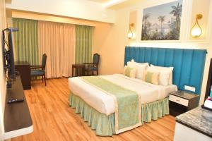 瓦斯科达伽马Hotel Royal Altis的酒店客房设有一张大床和蓝色床头板