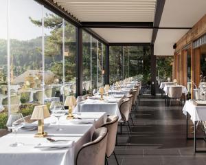 威拉尔-苏-罗伦莱斯麦祖杜克洛斯住宿加早餐旅馆的餐厅设有白色的桌椅和大窗户。
