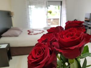 雷泽雷西德Spa卢瓦尔河& 瑟夫酒店的卧室里满是红玫瑰的花瓶
