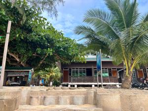 Kampong Pasir HantuMama's Chalet Pulau Perhentian Besar的前面有棕榈树的建筑