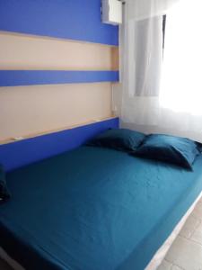 TsingoniLe Caferoom Club的窗户客房内的一张蓝色的床