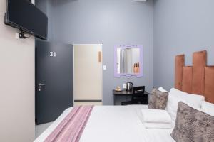 开普敦Cape palm royal guest house的卧室配有白色的床和电视