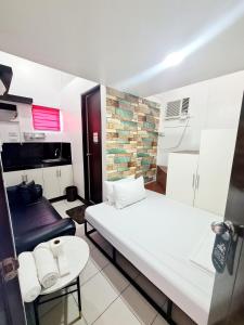 达斯马里尼亚斯Dasma Lofts Hotel near Dela Salle Dasma的小房间设有两张床和一张桌子
