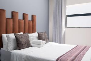开普敦Cape palm royal guest house的卧室配有一张带白色床单和枕头的大床。