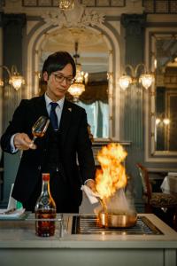 京都ホテル長楽館 京都 祇園的穿着西装的人在用火烧锅