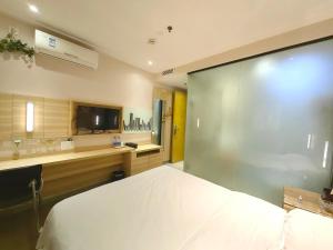 广州上下九城市快捷酒店的卧室配有一张白色大床和电视。