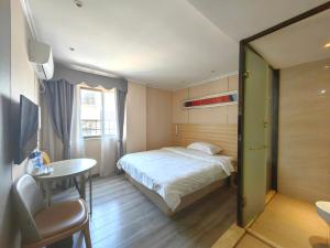 广州上下九城市快捷酒店的酒店客房配有一张床铺、一张桌子和一张书桌。