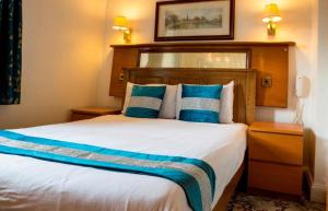 伦敦Aspen Hotel的一间卧室配有一张带蓝色枕头的大床