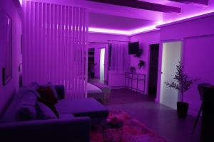 佩奇Secret Garden Vendégház的客厅配有紫色灯光和沙发