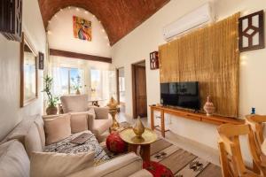 赫尔格达Makadi Heights Elite Residence - Hurghada, Red Sea的带沙发和电视的客厅