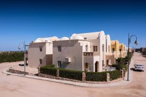 赫尔格达Makadi Heights Elite Residence - Hurghada, Red Sea的停车场里的一个大型白色房子