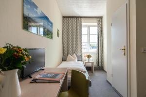 慕尼黑Hotel-Pension am Siegestor的酒店客房配有一张床和一张桌子