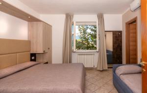 马里纳迪马萨埃乌拉酒店的一间卧室设有一张床和一个窗口