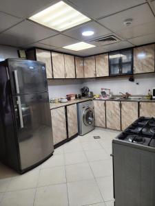 阿布扎比Hotel rooms inside private Apartment for Rent at Tourist Club Area的厨房配有冰箱和洗衣机。