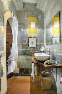 贝托勒Villa Vignacce - Boutique Country Resort的浴室设有水槽和带镜子的台面