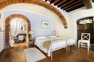 贝托勒Villa Vignacce - Boutique Country Resort的一间卧室设有一张床和砖墙