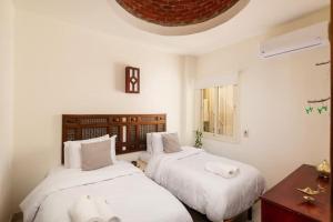 赫尔格达Makadi Heights Elite Residence - Hurghada, Red Sea的一间卧室配有两张带白色枕头的床