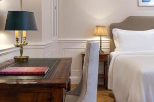 雅典King George, a Luxury Collection Hotel, Athens的酒店客房配有一张床和一张带台灯的书桌