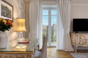 雅典King George, a Luxury Collection Hotel, Athens的客厅配有书桌和窗户。