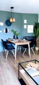 莫列马阿Appart Cosy Green, Océan, Golf, Piscine, Wifi的一间带木桌和椅子的用餐室