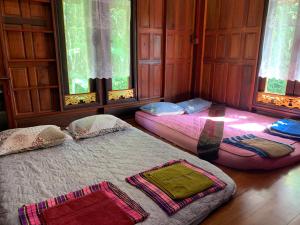 Ban Khu Ha Nai (1)โฮมสเตย์บ้านนายสิงโตเขาคูหา的配有窗户的客房内的两张床