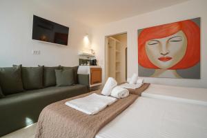 米克诺斯城23 Hotel Mykonos的客厅配有沙发和一幅女人画