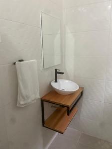 瓜鲁雅Pousada As Ondas的白色的浴室设有水槽和镜子